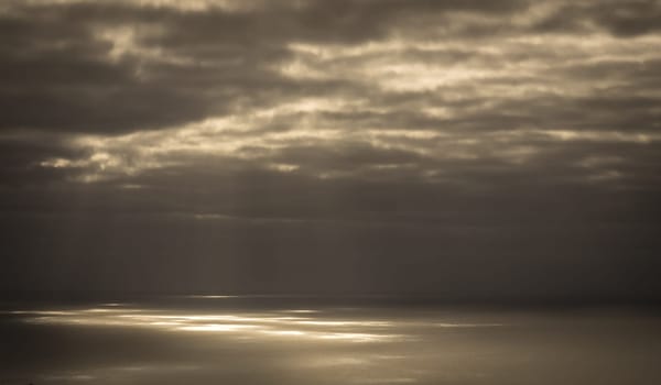 Light rays and clouds over the sea before sunset