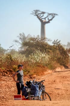 Cyclist resting in the famous Avenida de Baobab near Morondava in Madagascar