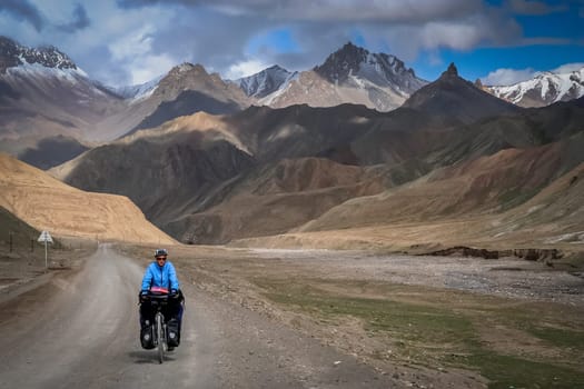 Solo female cyclist cycle touring through the stunning remote landscape of Western Tibet