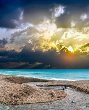Dramatic sunrise over the ocean and fresh water stream in Cornwall, United Kingdom