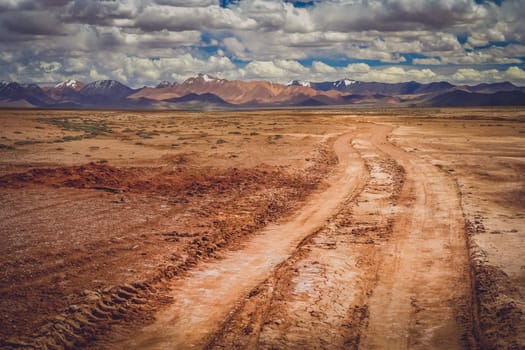 Muddy and clay mountain road through the high central Tibetan plateau, Tibet, China