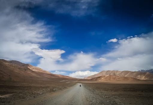 Solo female cyclist cycle touring through the stunning remote landscape of Western Tibet