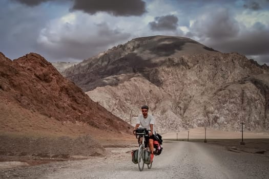 Solo male cycle touring through the stunning remote landscape of Western Tibet