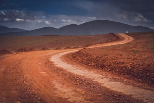 Snow falling in summer on a muddy and clay mountain road through the high central Tibetan plateau, Tibet, China