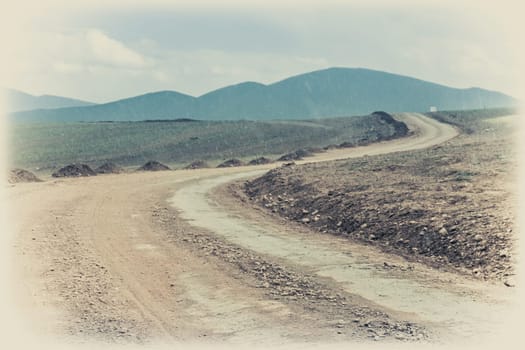 Snow falling in summer on a muddy and clay mountain road through the high central Tibetan plateau, Tibet, China