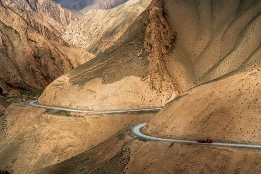 Chinese truck struggling and moving slowly on the stunningly beautiful mountain road through the Western Tibet, China