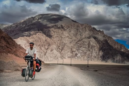 Solo male cycle touring through the stunning remote landscape of Western Tibet