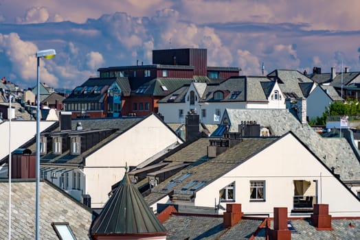 View on rooftops of Alesund, city in Norway, Scandinavia, Europe. Dramatic cloudy sky in background.