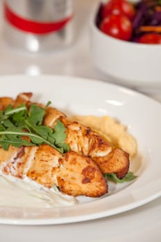 Grilled chicken meat skewers meal with rocket salad leaves, youghurt and peanut sauce
