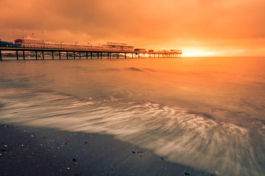 Paignton Pier on Paignton beach near Torquay in Devon during spectacular sunset