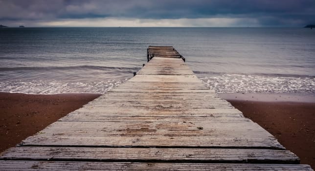 Small wooden pier leading into the sea in Paignton, Torbay, Devon, UK