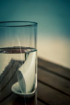 Coffee cup reflected in a glass with water