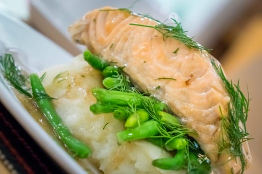 Roast salmon main course served with mashed potatoes and green beans