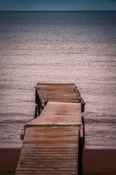 Small wooden pier leading into the sea in Paignton, Torbay, Devon, UK