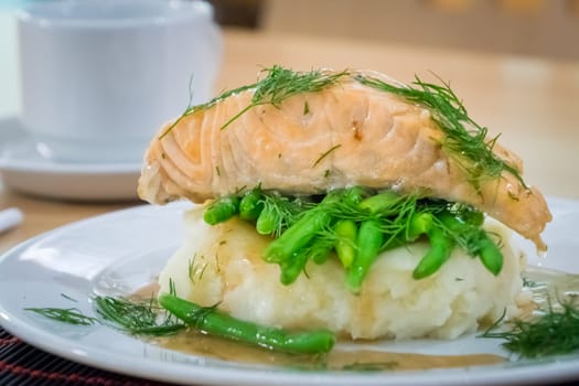 Roast salmon main course served with mashed potatoes and green beans