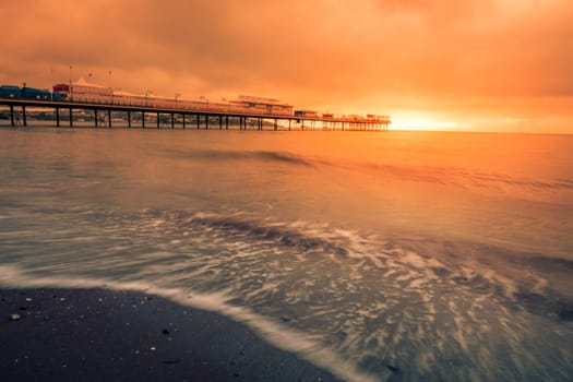 Paignton Pier on Paignton beach near Torquay in Devon during spectacular sunset