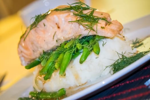 Roast salmon main course served with mashed potatoes and green beans