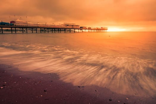 Paignton Pier on Paignton beach near Torquay in Devon during spectacular sunset