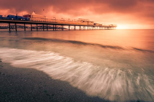 Paignton Pier on Paignton beach near Torquay in Devon during spectacular sunset