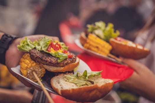 BBQ burgers and grilled corn during barbecue outdoors