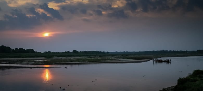 Tourists crossing the river in a small wooden canoe in Royal Chitwan National Park in Terai – Nepalese lowlands