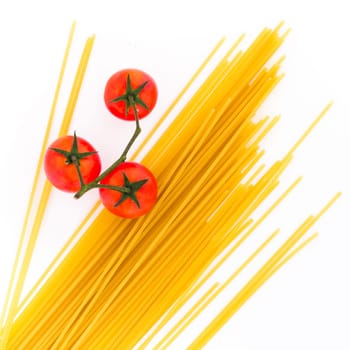 Spaghetti and cherry tomatoes isolated on white background. Uncooked Italian dried spaghetti. Top view. Flat lay..