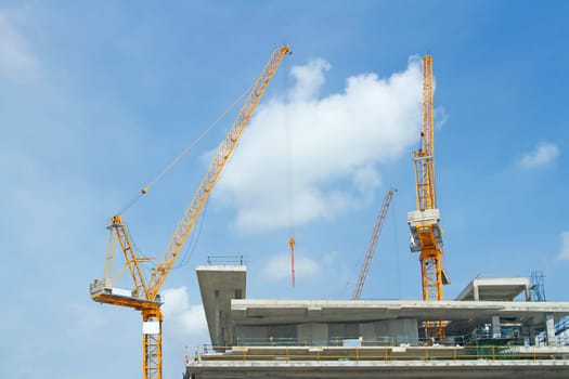 Inside place for many tall buildings under construction and cranes under a blue sky