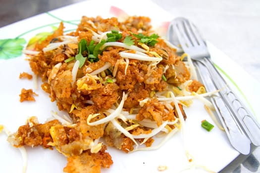 Oysters fried in egg batter in a white dish with spoon and mug