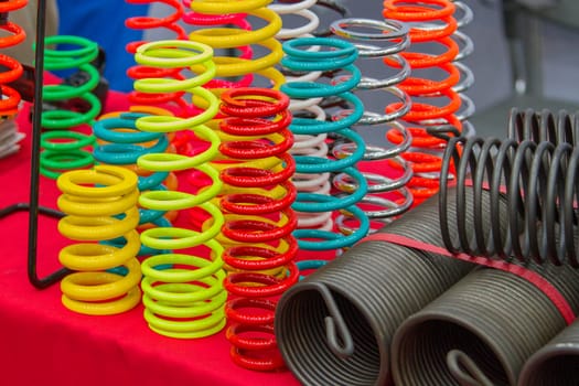 Coil springs are many colors on the red table.