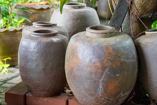 Black clay jar many sizes in a tree shade.