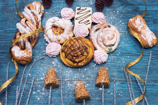Different cookies on blue wooden background for happy new year holiday, top view