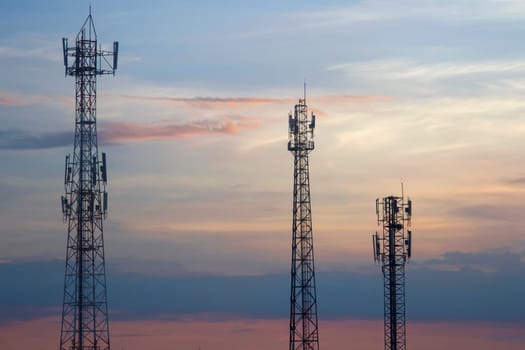 Three mobile phone communication tower transmission  signal  leash in evening sky