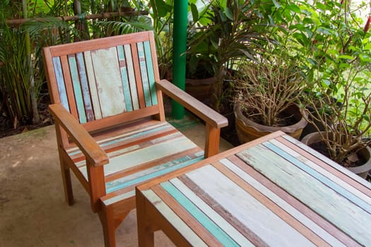 Table with wooden chair with green tree surrounded.
