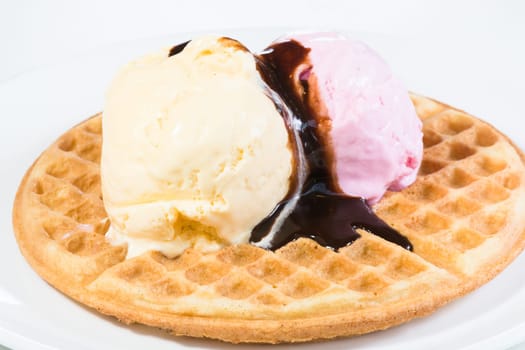 Vanilla and strawberry ice cream on a waffle and glazed with belgian chocolate sauce