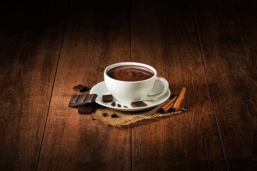 Cup of hot chocolate and cocoa on wooden background.