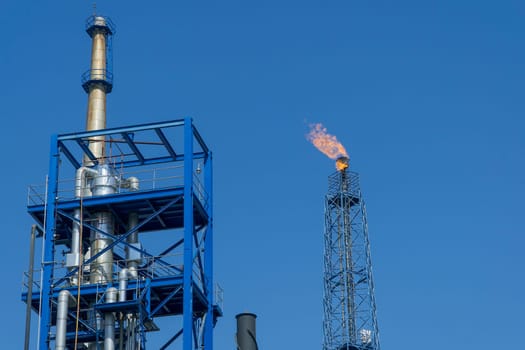Gas flares in petroleum refinery  with blue sky background