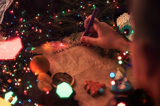 Boy's hand closeup, writing a letter to Santa, cristmas background