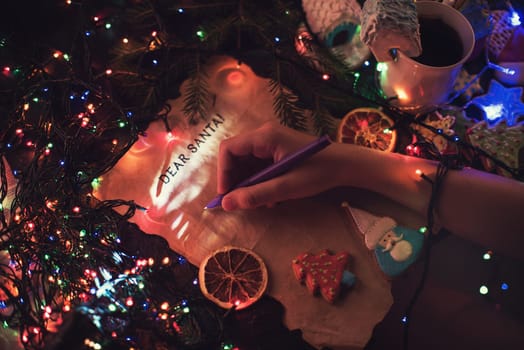 Boy's hand closeup, writing a letter to Santa, cristmas background