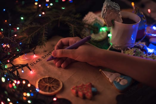 Boy's hand closeup, writing a letter to Santa, cristmas background