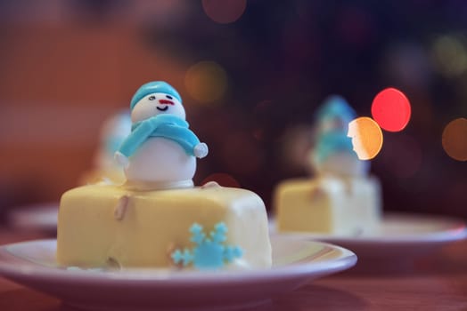 Christmas dessert with snowman on lights bokeh background