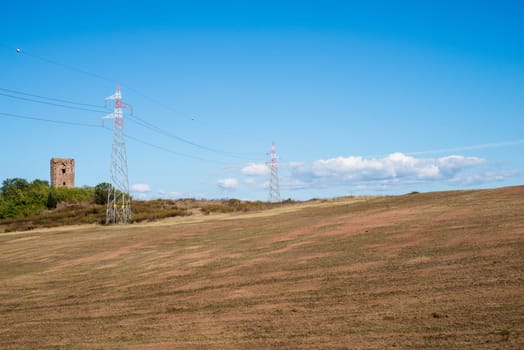 landscape of an ancient tower with power pylons