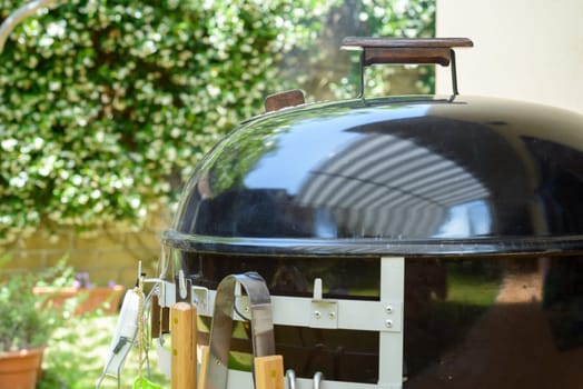 A closed barbecue during pulled pork cooking day, with tools