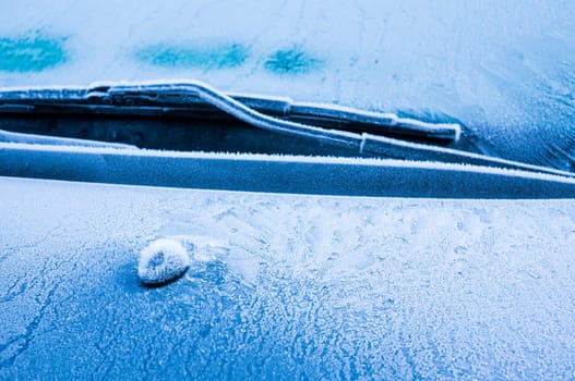 Iceflowers, frozen.The ice-cold frost forms ice crystals in beautiful unique patterns on the window, Hood and wiper on the Car