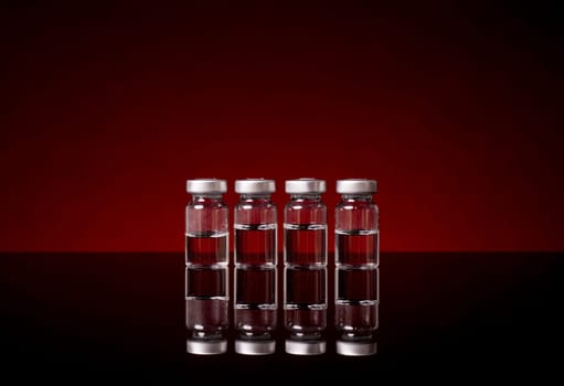 Medical Vials with clear liquid isolated og red black background