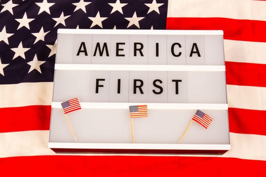 Light box with letters - AMERICA FIRST - on an American national flag