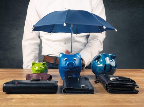 Businessman holding a small blue umbrella, protection or security concept image, protect your savings