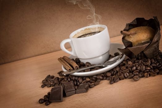 coffee cup with coffee beans, chocolate and muffin