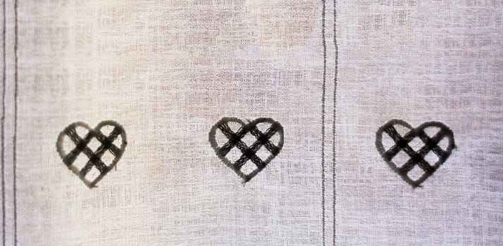 ornamental hearts sewn on a textile curtain