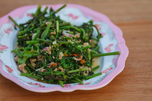 Vegetable fern spicy salad on wooden background