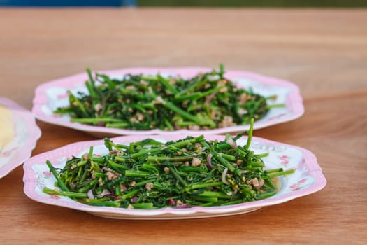 Vegetable fern spicy salad on wooden background